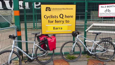 Cyclist-queue-here-sign-and-waiting-point-for-Caledonian-Macbrayne-ferry-at-Oban-harbour-to-Barra-in-the-Outer-Hebrides,-Scotland-UK