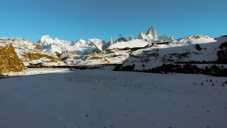 Rio-de-las-Vueltas-valley-in-winter,-with-Fitz-Roy-and-an-Andean-condor-flying