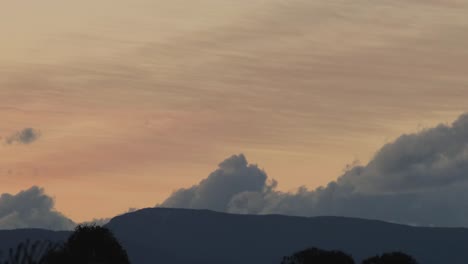 Enormes-Nubes-Ondulantes-Formándose-Detrás-De-La-Montaña-Puesta-De-Sol-Anochecer-Crepúsculo-Timelapse-Australia-Maffra-Gippsland-Victoria