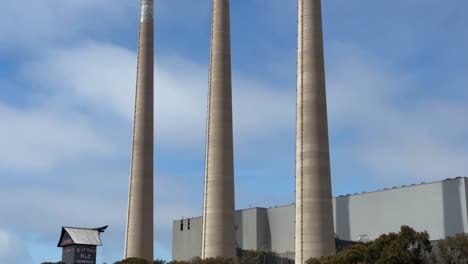 Primer-Plano-Cinematográfico-Inclinado-Hacia-Arriba-De-Las-Icónicas-Tres-Chimeneas-De-La-Central-Eléctrica-De-Morro-Bay-En-Morro-Bay,-California.