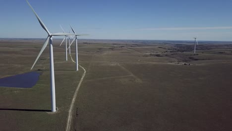 Aerial-drone-footage-of-windmills-during-summer-over-farm-fields-in-Kansas,-United-States