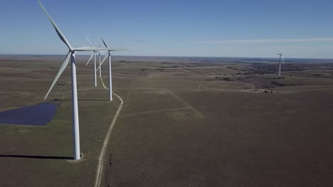 Imágenes-Aéreas-De-Drones-De-Molinos-De-Viento-Durante-El-Verano-Sobre-Campos-Agrícolas-En-Kansas,-Estados-Unidos