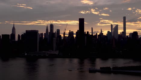 Time-Lapse-of-Sunset-and-traffic-at-Midtown,-Manhattan,-New-York-City,-the-East-River-and-Roosevelt-Isand-in-the-foreground,-filmed-from-Long-Island-City-at-June-2019