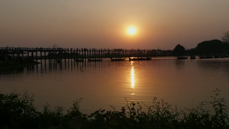 Silhouette-Des-Wunderschönen-Sonnenuntergangs-An-Der-Historischen-U-Bein-Teakholzbrücke-In-Amarapura-In-Der-Nähe-Von-Mandalay,-Myanmar,-Der-ältesten-Und-Längsten-Fußgängerbrücke-Aus-Teakholz-Der-Welt