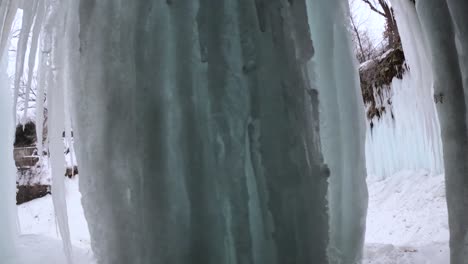 Hiking-behind-a-frozen-ice-cave-at-Minnehaha-Falls,-Minnesota