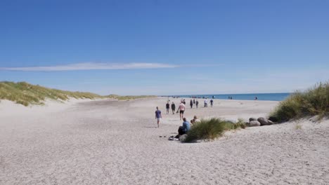 Personas-Y-Familias-Caminando-Por-La-Popular-Playa-De-Skagen-En-Verano,-Toma-Amplia-Con-Cámara-En-Mano