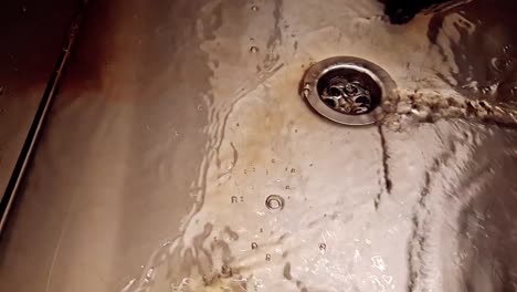 Washing-blood-in-a-silver-stainless-steel-sink-in-slow-motion