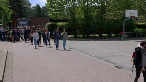 Children-entering-the-school-on-a-sunny-day-through-the-gate,-time-lapse