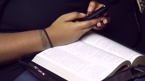 Afroamerikanischer-Schwarzer-Millennial-Mit-Tätowierungen,-Der-Handy-Technologie-Beim-Lesen,-Studieren-Der-Bibel,-Des-Christentums-Und-Des-Wortes-Gottes-Nutzt