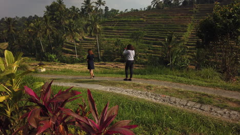 Unidentified-women-walk-on-path-while-looking-at-mobile-phones-in-Jatiluwih-Rice-Terrace