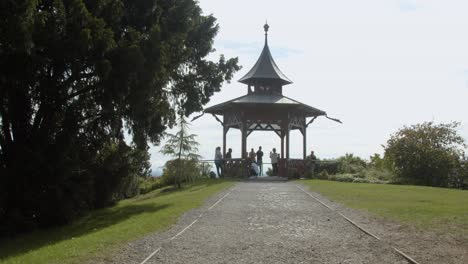 Tourists-taking-photos-around-the-Chinese-pavilion-on-Schlossberg-castle-park,-wide-shot