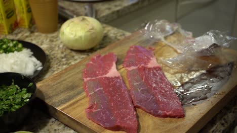 Laying-Out-Steak-on-a-Wooden-Cutting-Board-in-Slow-Motion