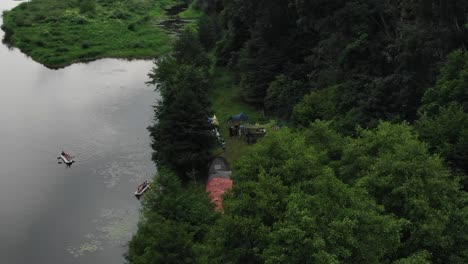 Luftaufnahme-Von-Menschen,-Die-In-Zelten-Im-Wald-Entlang-Eines-Flusses-Campen