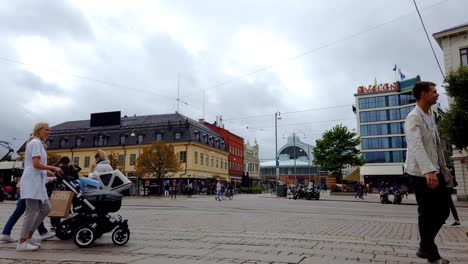 Central-Gothenburg-scene,-trams-and-people-moving,-busy-cityscape-time-lapse-pan