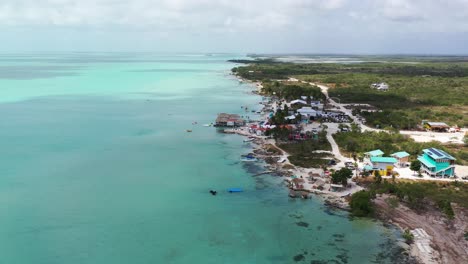 Drone-footage-of-tropical-San-Pedro-coastline-in-Belize-lined-with-wooden-homes