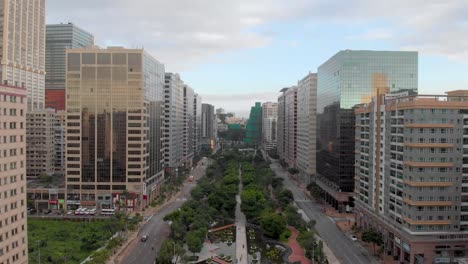 Backwards-reveal-of-NAPE-business-area-and-park-in-Macau,-during-golden-hour