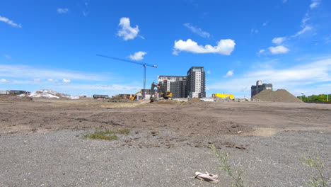 Timelapse-of-construction-site,-excavator-and-heavy-machinery-in-action,-working-and-loading-sand-in-truck,-beautiful-sky-and-clouds