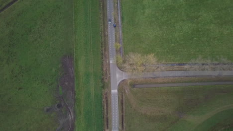 Toma-Aérea-De-Un-Drone-Sobre-El-Paso-Elevado-De-La-Carretera-Con-Cruce-En-T-En-El-Campo-De-Los-Países-Bajos