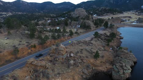 Cars-On-Mountain-Valley-Road-By-Lake-Aerial-Reveal-Shot-4K