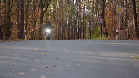 Motorcyclist-rides-on-his-motorcycle-through-the-autumn-forest