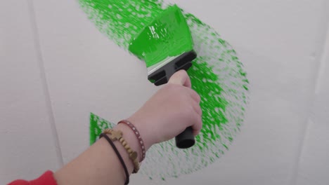 Close-up-of-a-letter-being-painted-on-a-white-wall-with-a-paint-brush