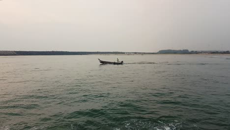 4k-Tracking-Shot-of-a-Fisherman-Boat-going-towards-the-sea-near-the-Old-Harbor,-Pondicherry,-India