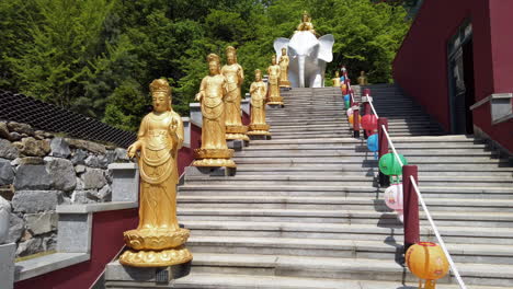 Golden-statues-on-stone-steps-with-elephant-sculpture-and-colorful-lanterns