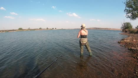 Beautiful-girl-fishing-at-a-calm-lake-on-a-sunny-day-in-South-Africa
