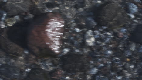 Close-up-slide-shot-of-stones-covered-in-water-of-the-Baltic-sea