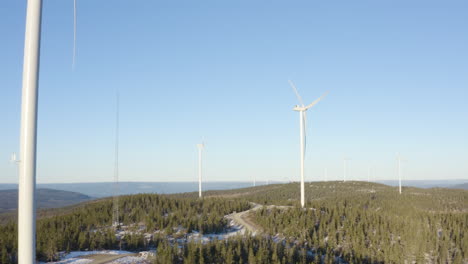 Strong-Windmill-Stems-Above-Trees-Showing-The-Beautiful-Landscape-Of-Osen,-Norway---Aerial-Panning-Shot