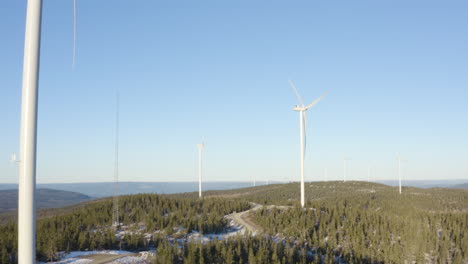 Fuertes-Tallos-De-Molino-De-Viento-Sobre-Los-árboles-Que-Muestran-El-Hermoso-Paisaje-De-Osen,-Noruega---Toma-Panorámica-Aérea