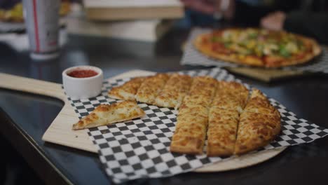 Eating-pizza-and-salad-with-with-friends-at-the-table-with-books-and-beer