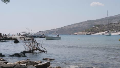 A-few-boats-anchored-near-Alyki-beach-in-Thasos,-Greece