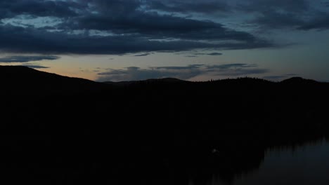 4K-Drohnenaufnahmen-Vom-Flug-Zum-Seeufer-In-Der-Abenddämmerung-Mit-Violettem-Alpenglühen-Am-Himmel