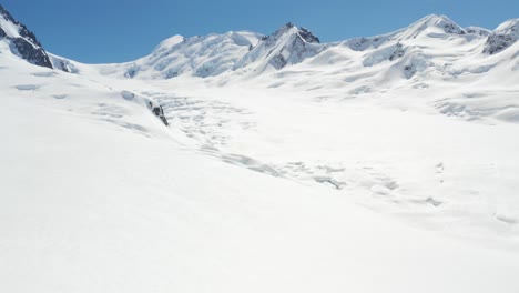 4K-drone-footage-flying-over-massive-glacier-in-mountains-on-bright-sunny-day