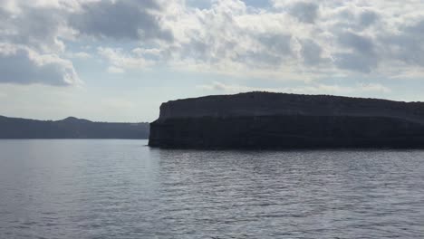 Sailing-by-Aspronisi-Island-revealing-Santorini-in-Mediterranean-Sea