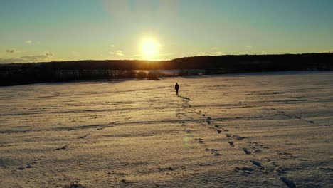 Hombre-Caminando-Solo-En-La-Nieve-Durante-El-Atardecer