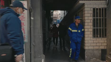 Movement-of-people-in-street-of-Xuhui-district,-woman-putting-on-mask