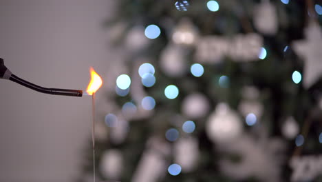 Newyear-party-firework-sparkler-with-blurry-Christmas-tree-in-the-background