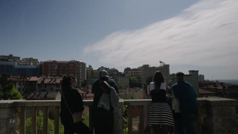 People-looking-at-Trieste-town,-Italy,-from-a-historic-terrace-on-a-winter-sunny-day