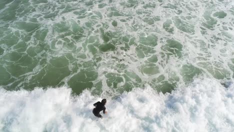 Intermidiaite-Surfer-Beim-Wellenreiten,-Von-Hinten-Gezeigt