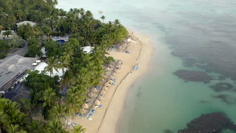 Vista-De-Drones-Del-Océano,-Sombrillas-Y-Playa-De-Arena-Caribeña,-Playa-Grand-Bahia-Principe-En-La-Península-De-Samana,-República-Dominicana