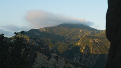 Puesta-De-Sol-Con-Vistas-A-Una-Montaña-Mientras-Las-Nubes-Pasan-Con-Sombras-Subiendo-La-Pendiente