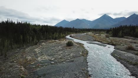 Río-Que-Fluye-En-El-Yukón-Con-Montañas-Al-Fondo