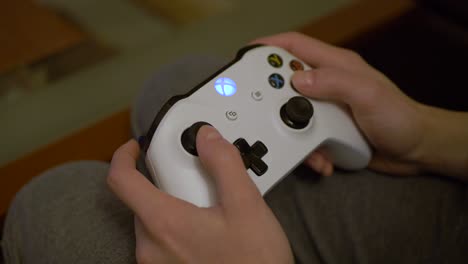 Close-up-shot-of-woman's-hand-playing-video-game-with-a-xbox-one-joypad-controller