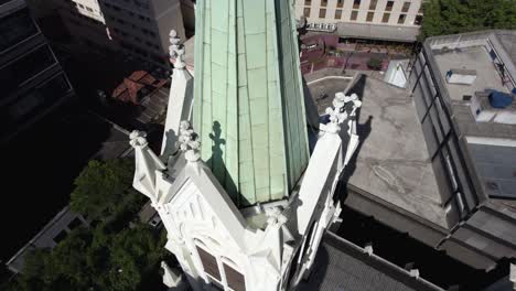 Aerial-view-close-to-the-tower-of-the-Presbyterian-Church,-revealing-the-cityscape-of-Republica,-São-Paulo,-Brazil---Ascending,-tilt,-drone-shot