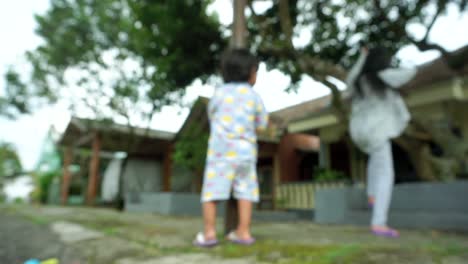 Close-up-blur-shot-of-two-kids-playing-in-the-garden-area