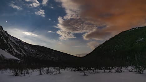 Timelapse-of-clouds-passing-on-a-starry-sunrise-sky-at-a-snowy-Hielo-Azul-Hill,-El-Bolsón,-Patagonia-Argentina