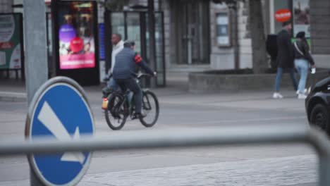 man-on-bike-in-the-city-center,-pedestrians-walk-on-street,-concept-of-modern-vehicles,-road-safety