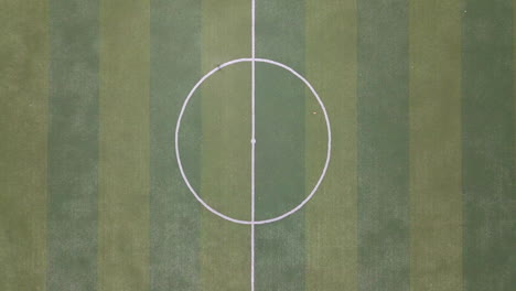 Revealing-straight-up-shot-in-4k-of-empty-mini-soccer-field-surrounded-by-park-and-trees-in-a-gated-community-outside-Guayaquil-City,-Ecuador